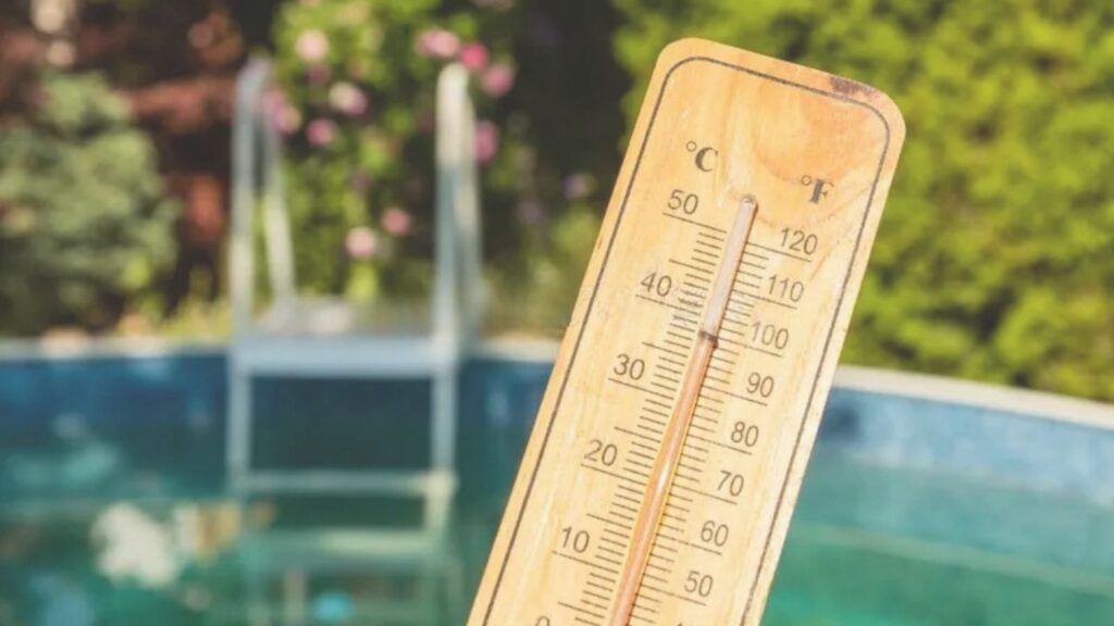 "Outdoor thermometer in Murrieta showing summer temperatures near 100 degrees, with a pool in the background.