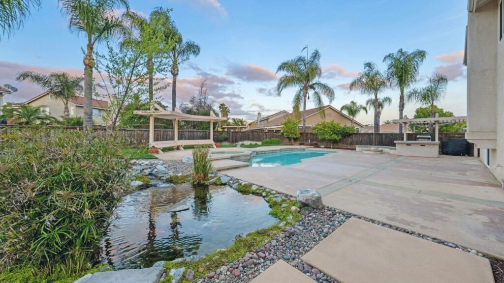 Spacious backyard in Murrieta with a private pool, patio, and koi pond—showcasing the value and outdoor lifestyle local homeowners enjoy.